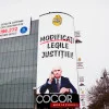 FOTO | Banner gigantic cu Ilie Bolojan afișat pe magazinul Cocor din centrul Bucureștiului. Declic cere modificarea legilor Justiției